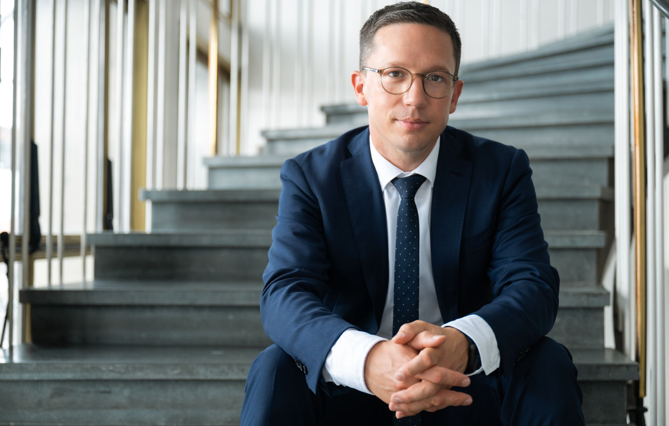 Porträtfoto von Falko Mohrs, auf einer Treppe sitzend