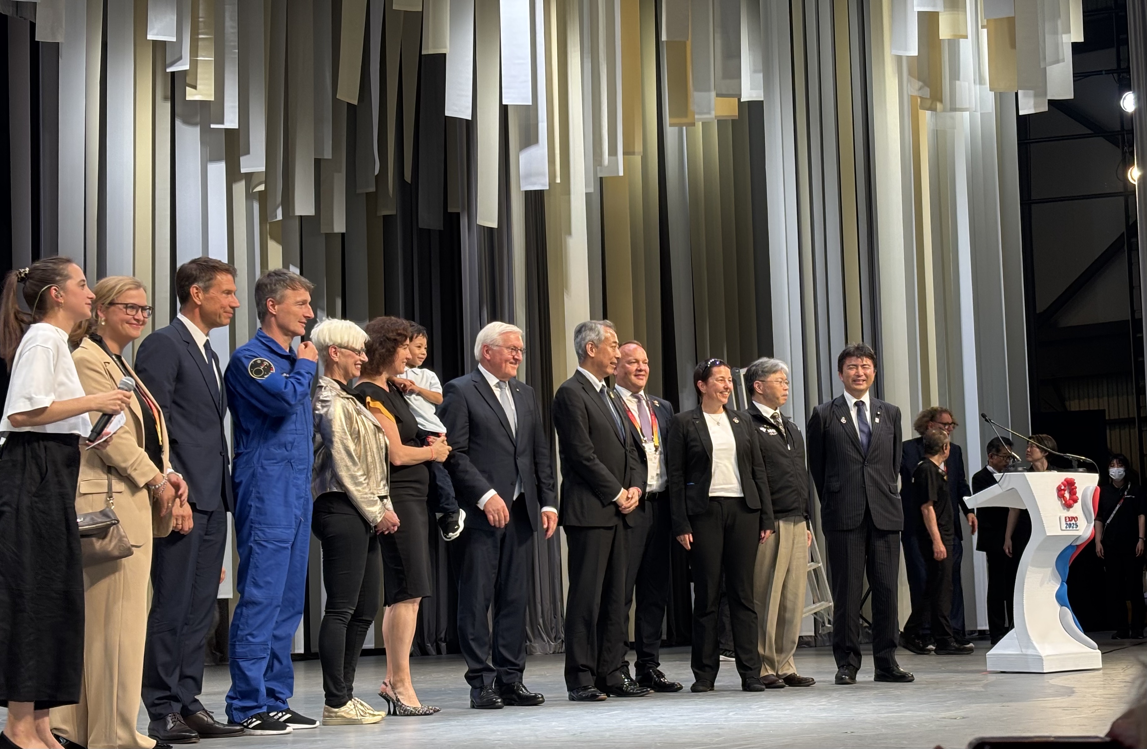 Gruppe von Menschen auf einer Bühne in Japan, darunter Frank-Walter Steinmeier und Dorothee Bär.