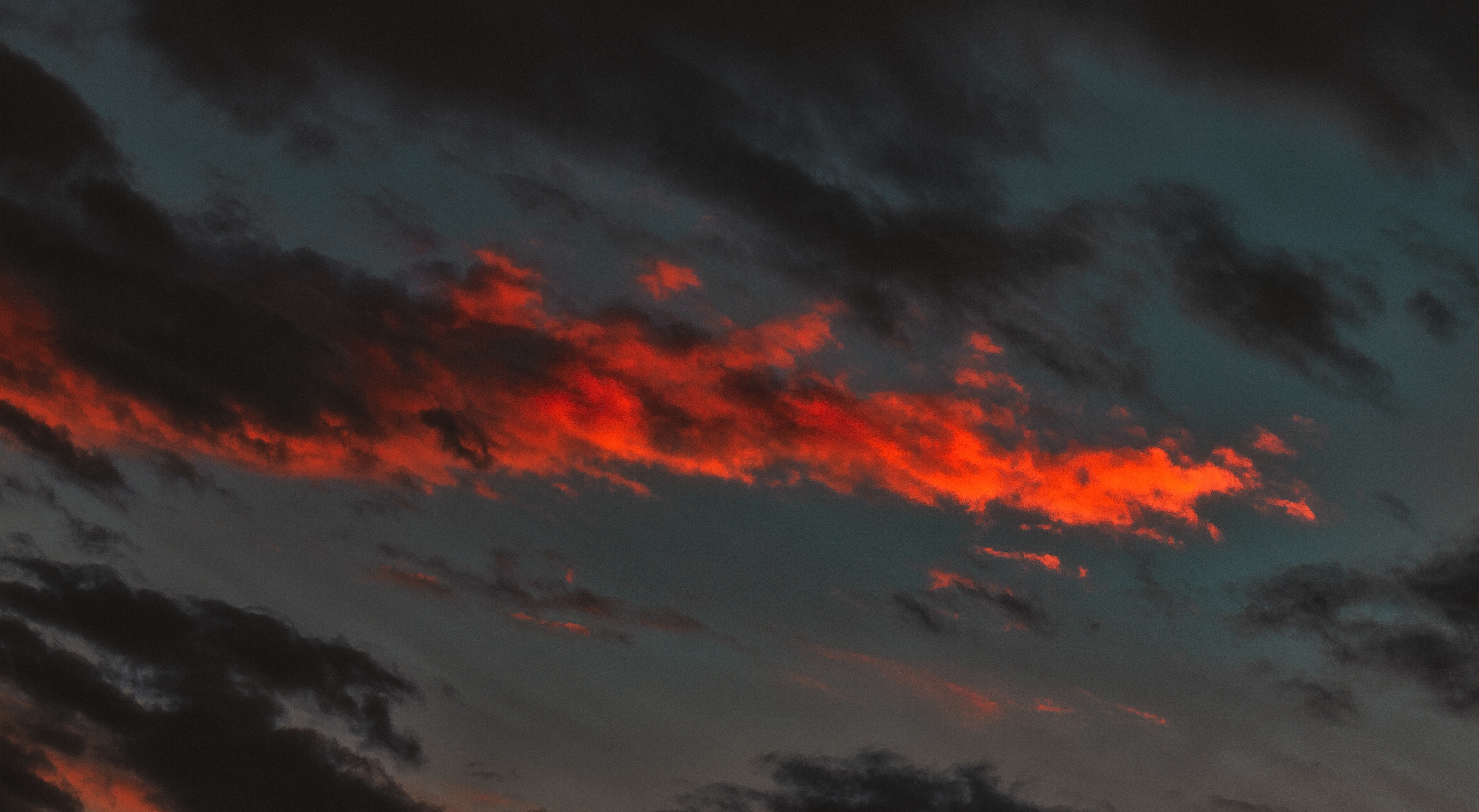 Dunkler Himmel, orange und schwarze Wolken.