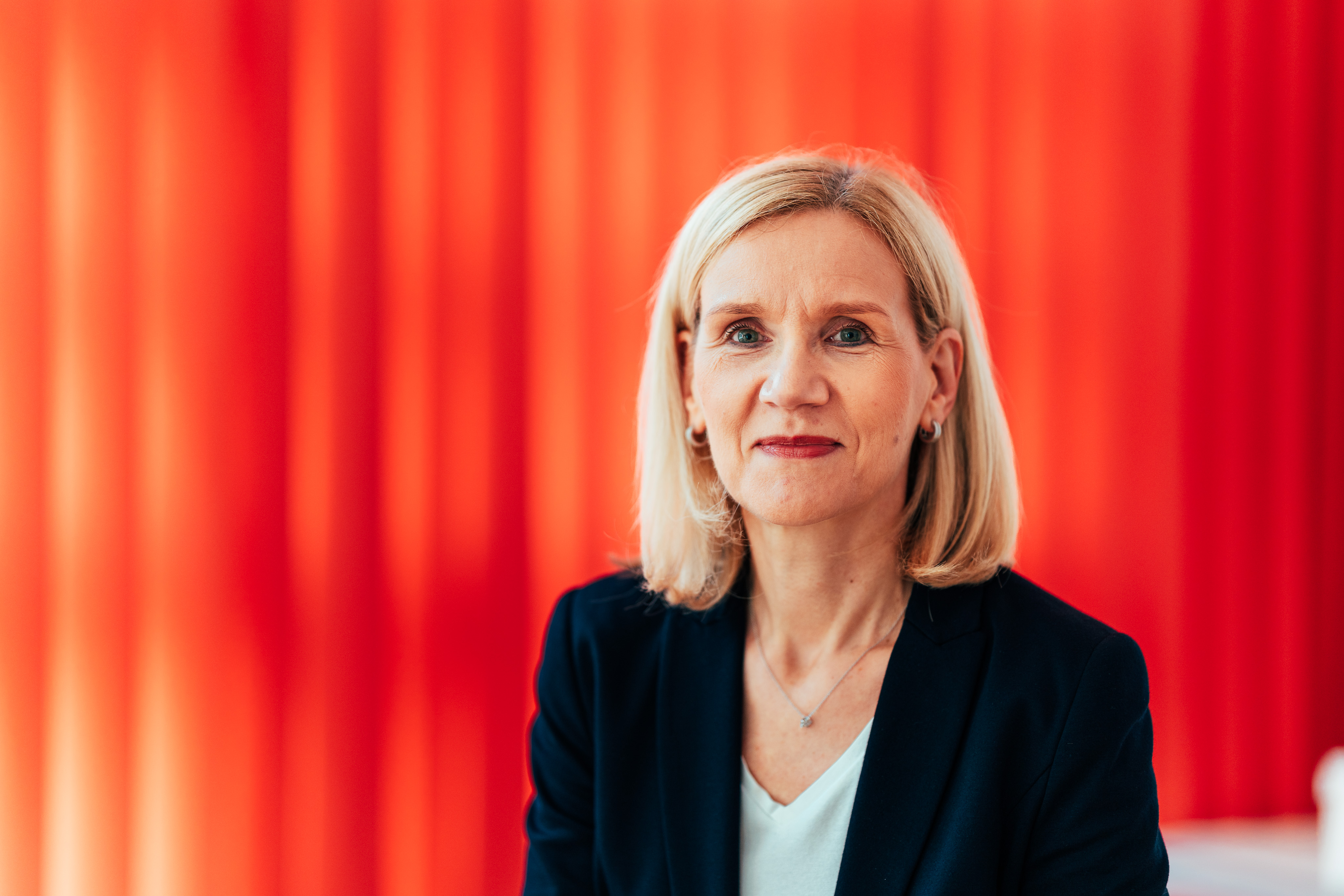 Portraitfoto Jutta Günther vor rotem Vorhang.