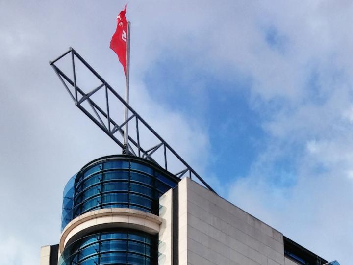 Spitze des Willi-Brandt-Hauses vor leicht bewölktem Himmel.