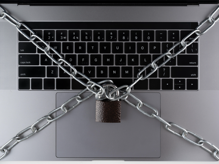 Laptop-Tastatur mit Kette und verriegeltem Vorhaengeschloss.