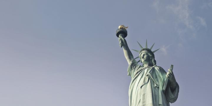 Bild vom Oberkoerper der Statue of Liberty in New York vor grauem Himmel.
