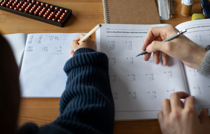 Draufsicht zwei Schueler bearbeiten Matheaufgaben.
