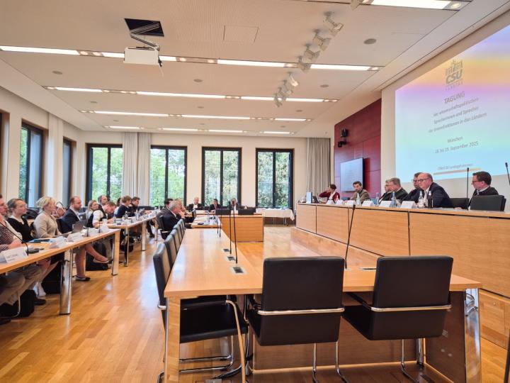 Aufnahme Plenarsaal mit Menschen bei einer Tagung.