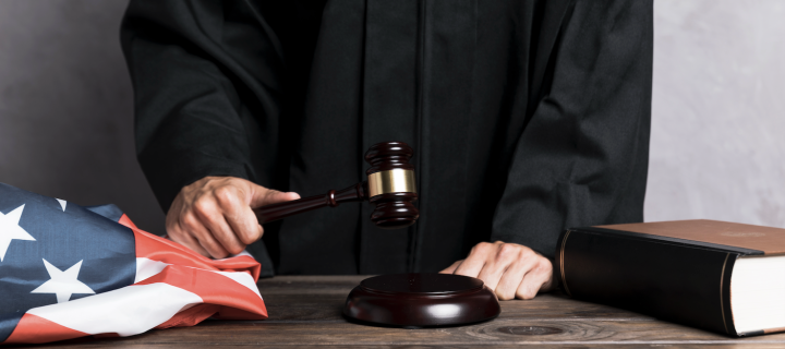 Close-Up Richter schlägt Hammer, amerikanische Flagge und Gesetzbuch.