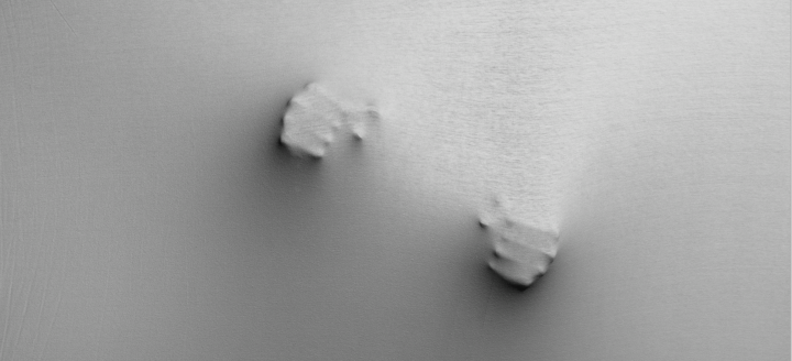 Zwei geballte Faeuste druecken sich durch eine gespannte Leinwand.