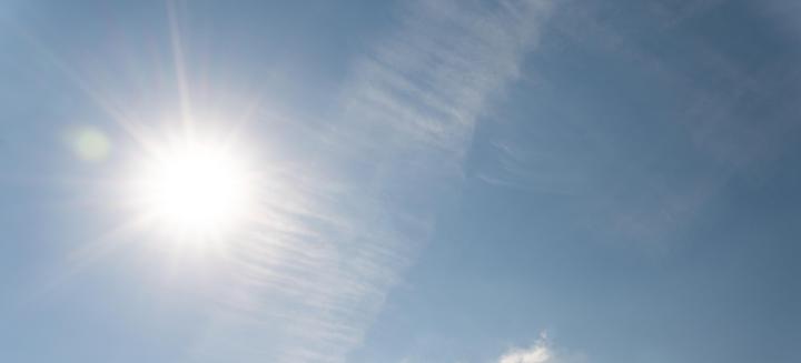 Sonne am blauen Himmel mit einzelnen Wolkenschleiern.