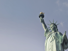 Bild vom Oberkoerper der Statue of Liberty in New York vor grauem Himmel.
