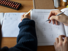 Draufsicht zwei Schueler bearbeiten Matheaufgaben.