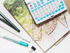 Collage aus Stiften, Heftern, Klammern und einem Taschenrechner.