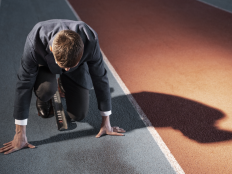 Mann im Anzug, startbereit zum Sprint.