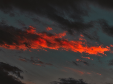 Dunkler Himmel, orange und schwarze Wolken.