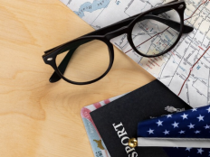 Collage aus Kartenausschnitt USA, Brille, Reisepass, Ausweis und einer kleinen amerikanischen Flagge.