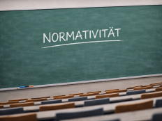 Tafel in Hoersaal, auf der das Wort "Normativitaet" zu lesen ist.