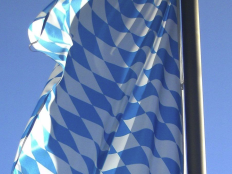 Ausschnitt einer Bayerischen Flagge, die vor blauem Himmel weht.