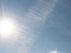 Sonne am blauen Himmel mit einzelnen Wolkenschleiern.