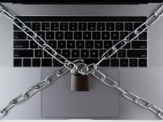 Laptop-Tastatur mit Kette und verriegeltem Vorhaengeschloss.
