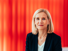 Portraitfoto Jutta Günther vor rotem Vorhang.