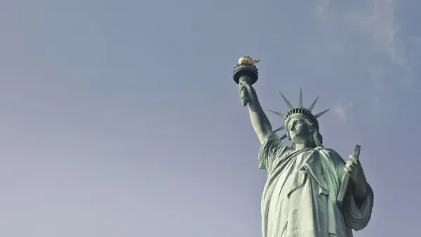 Bild vom Oberkoerper der Statue of Liberty in New York vor grauem Himmel.