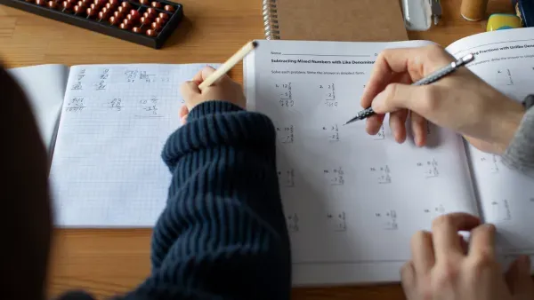 Draufsicht zwei Schueler bearbeiten Matheaufgaben.
