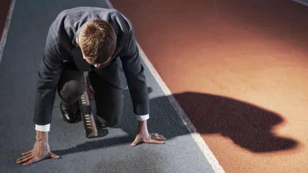 Mann im Anzug, startbereit zum Sprint.