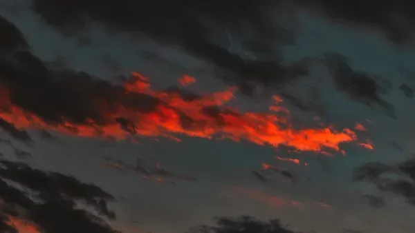 Dunkler Himmel, orange und schwarze Wolken.