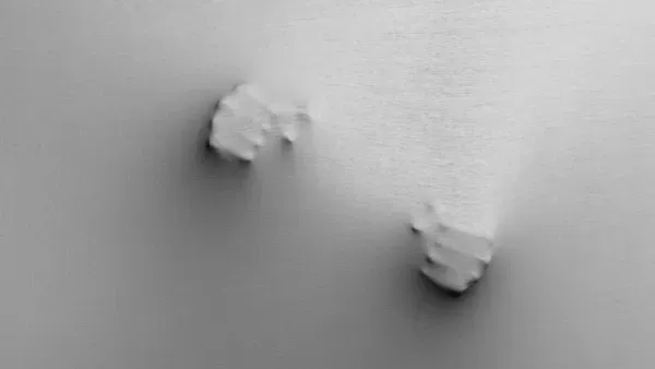 Zwei geballte Faeuste druecken sich durch eine gespannte Leinwand.