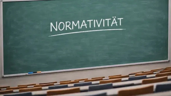 Tafel in Hoersaal, auf der das Wort "Normativitaet" zu lesen ist.