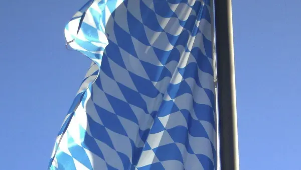 Ausschnitt einer Bayerischen Flagge, die vor blauem Himmel weht.