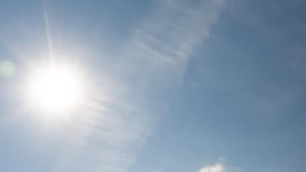 Sonne am blauen Himmel mit einzelnen Wolkenschleiern.