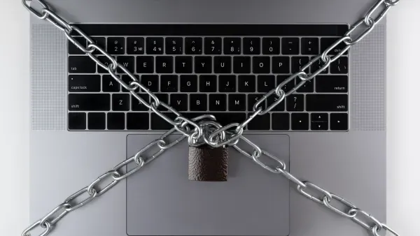 Laptop-Tastatur mit Kette und verriegeltem Vorhaengeschloss.